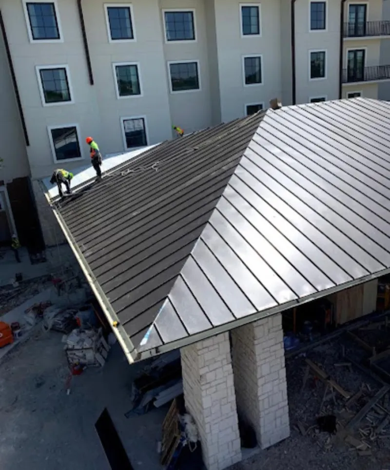 Crew installing standing seam metal roof panels on a commercial project in Wilmington